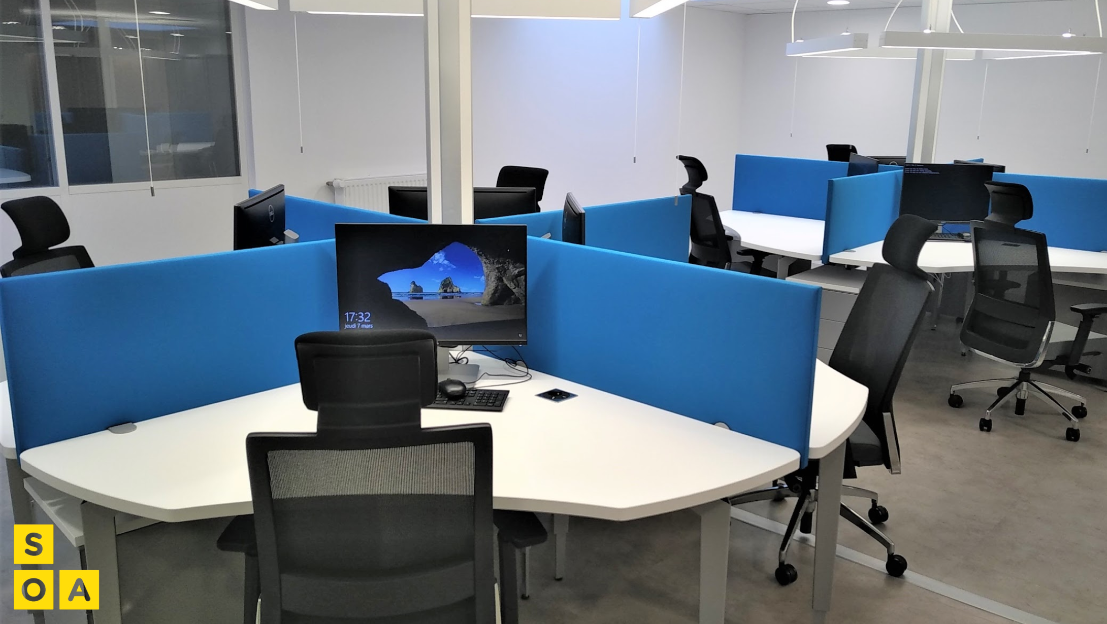 Poste de travail collaboratif avec cloison bleue et mobilier technique SOA