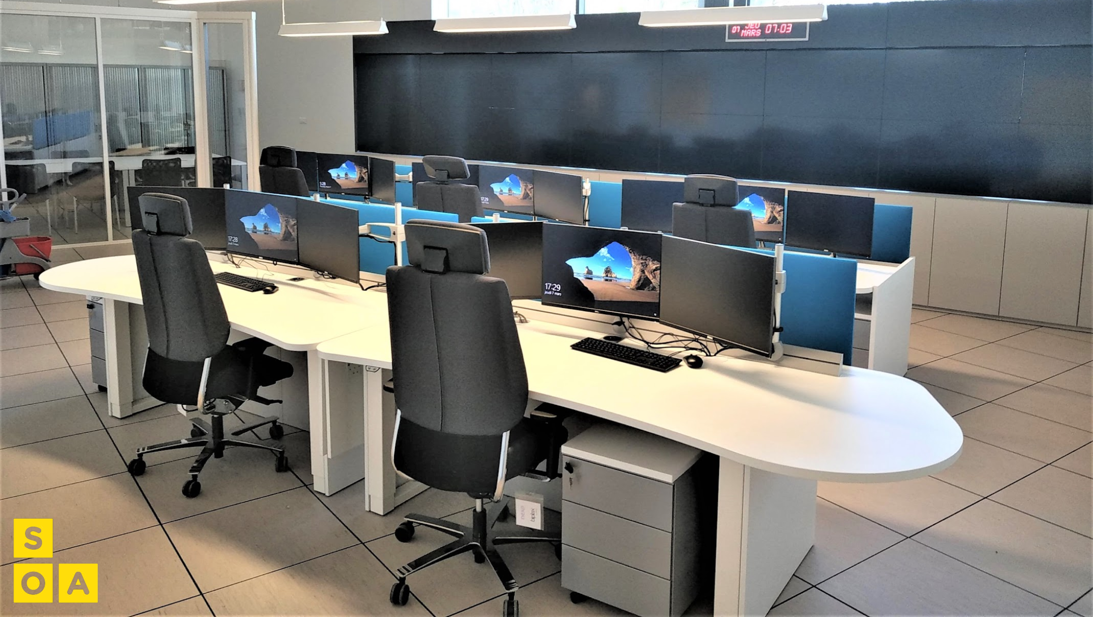Salle de réunion avec écran de supervision et mobilier blanc SOA